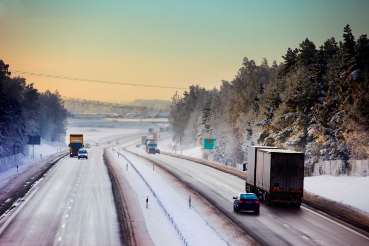 Motorväg med trafik i vinterlandskap.