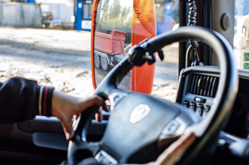 Närbild på ratt och hand som kör lastbilen.. 