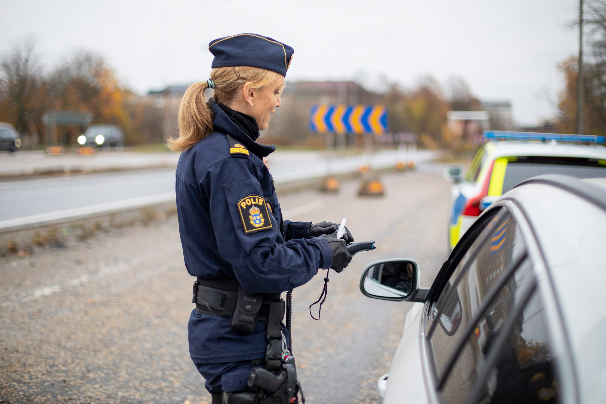 Polis genomför trafikkontroll vid vägkanten, fotografi