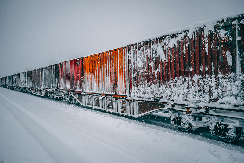 Snöiga godsvagnar på vintriga järnvägsspår