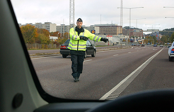 Bil på polisman som visar tecken för att stanna