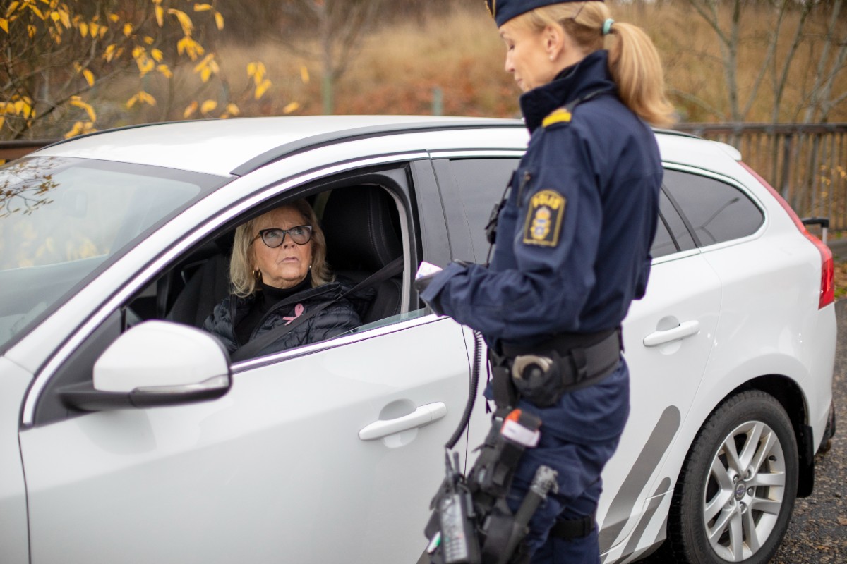 Bild på en polis som utför en körkortskontroll.